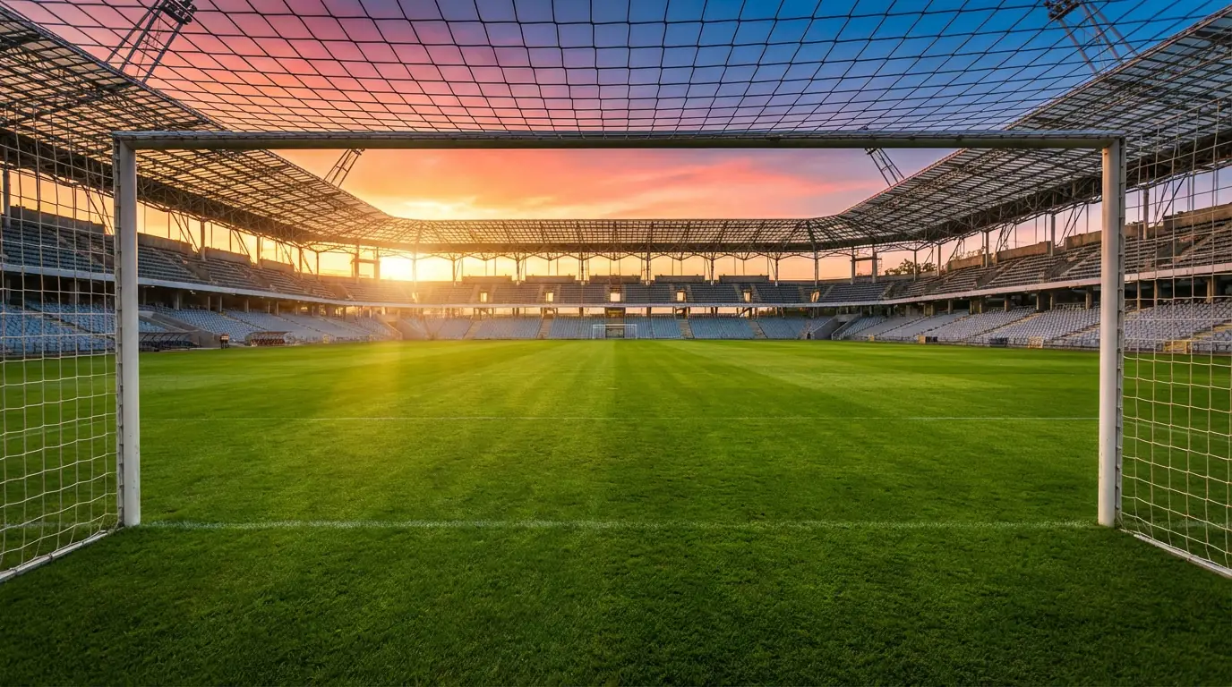 Campo da calcio con erba verde illuminato dalla luce del tramonto prima di una partita