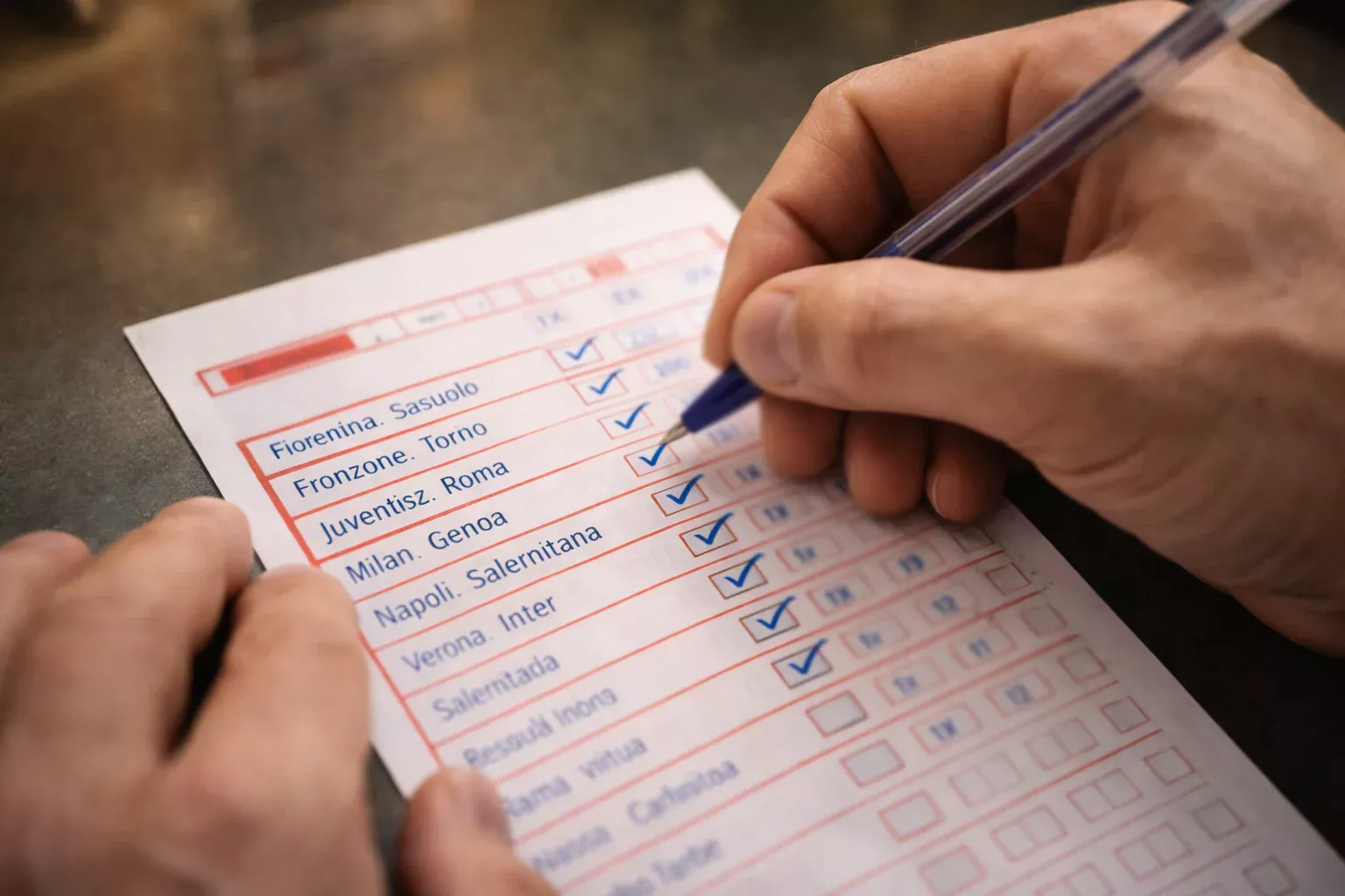 Mano che compila schedina con più pronostici per la stessa partita